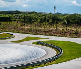 A Porsche races around the Porsche Experience Center in Atlanta as a Delta airplane comes in for a landing